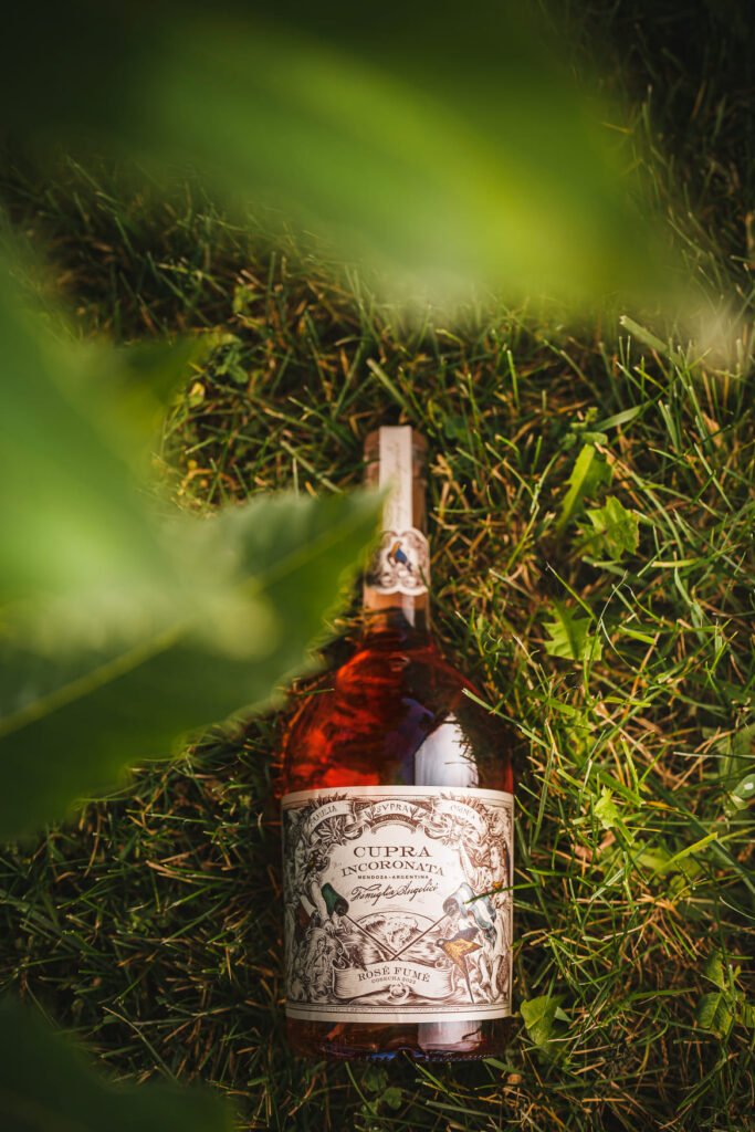 Botella Cupra Incoronata Rosé entre follaje verde, estilo editorial